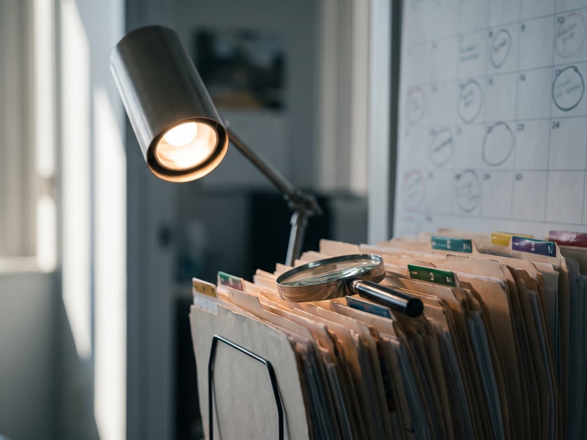 A spotlight and magnifier over stacked Medicare Advantage medical-record folders beside a calendar, marking the PY2024 RADV audit deadline.